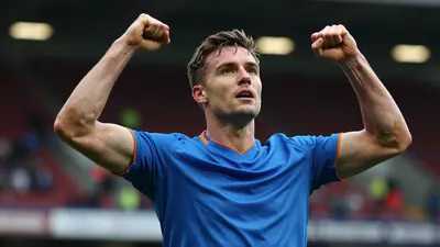 Barrow midfielder, early-30s, athletic build, waist-up, head-and-shoulders framing, face sharp and expressive, eyes...