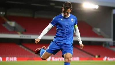 A tight waist-up shot of an anonymous Barrow player in a blue kit with white sleeves and shorts, looking determined as...