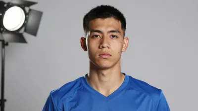 Photorealistic head-and-shoulders of a 26-year-old athletic forward in a solid blue kit, smooth fabric texture