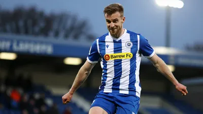 A photorealistic image of an anonymous Barrow AFC player, aged 25-30, wearing a blue and white striped jersey with a...