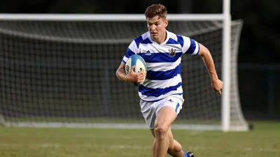 A tight action crop of a young, athletic, Barrow player in a blue and white striped shirt, with a white collar and...